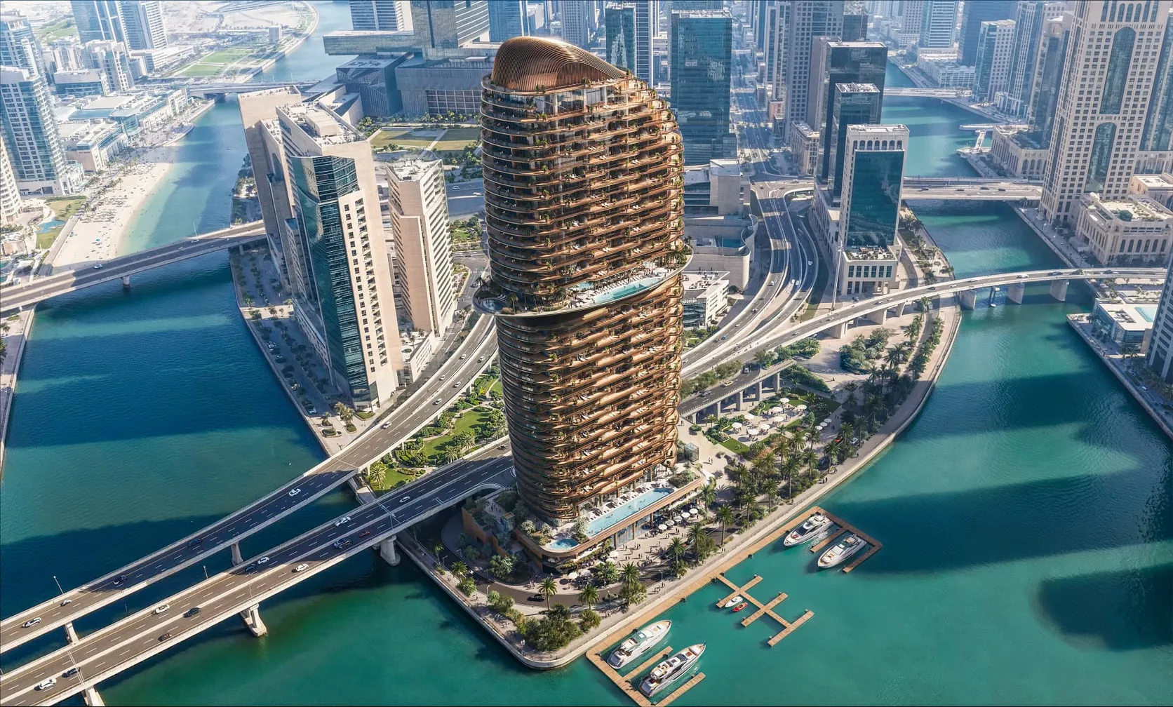 Aerial view of a curved waterfront tower with bronze balconies rising above a Dubai marina, water channels and city skyline